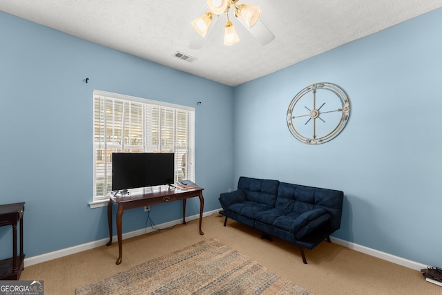 sitting room with carpet flooring, baseboards, visible vents, and a textured ceiling