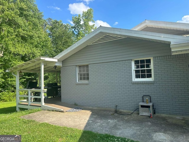 view of side of property featuring a patio and brick siding