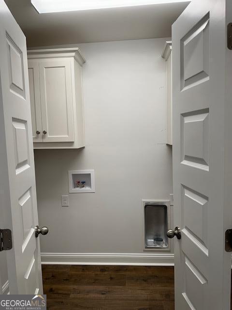 clothes washing area with baseboards, cabinet space, washer hookup, and dark wood-style flooring