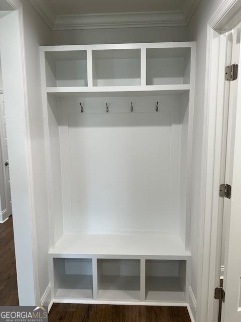mudroom with dark wood-style flooring and ornamental molding