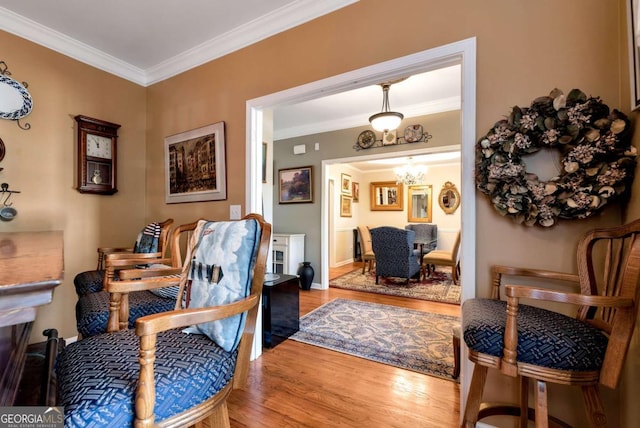 interior space with baseboards, a notable chandelier, wood finished floors, and ornamental molding