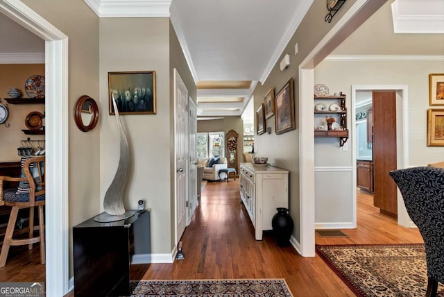 corridor with ornamental molding, baseboards, and wood finished floors