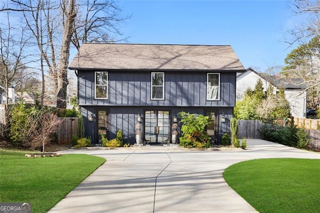 view of front of home featuring a front lawn, fence, and driveway