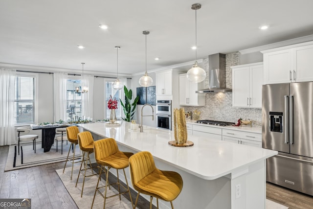1322 Stanley Park Dr, Decatur, GA 30033 - kitchen with light countertops, wall chimney exhaust hood, appliances with stainless steel finishes, a kitchen island with sink, and decorative backsplash