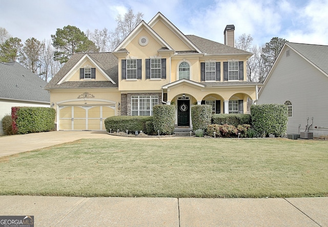 view of front of home featuring stucco siding, driveway, a front yard, a garage, and a chimney