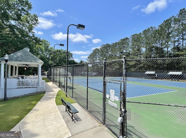 view of tennis court featuring a gate and fence