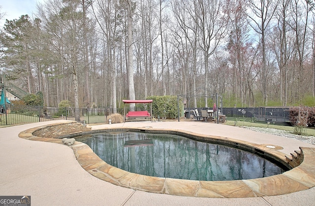 view of swimming pool featuring a fenced in pool, a patio, and fence