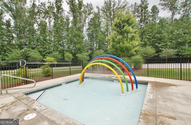 view of pool featuring fence and view of scattered trees