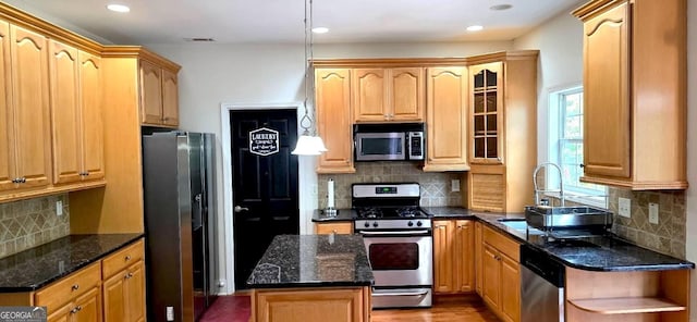 kitchen featuring appliances with stainless steel finishes, backsplash, dark stone counters, recessed lighting, and glass insert cabinets