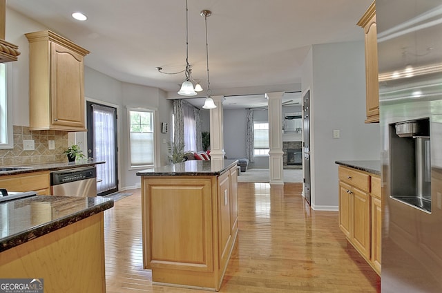 65 Tapestry Ln, Newnan, GA 30265 - kitchen with decorative columns, stainless steel appliances, a kitchen island, light brown cabinets, and decorative backsplash