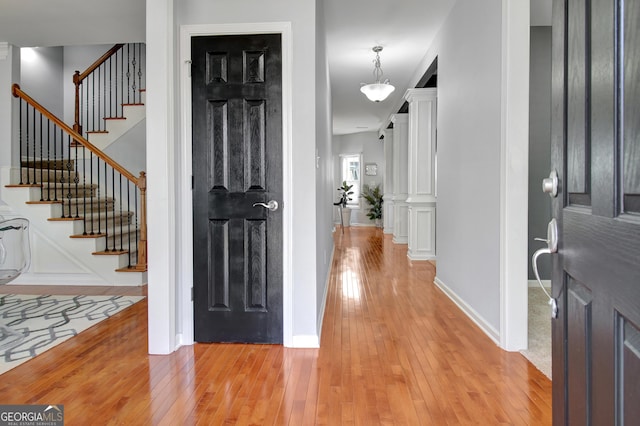 entrance foyer with stairway, baseboards, and light wood-style floors