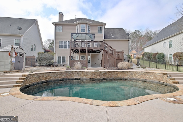 back of house featuring a patio, fence, stairway, a wooden deck, and a chimney