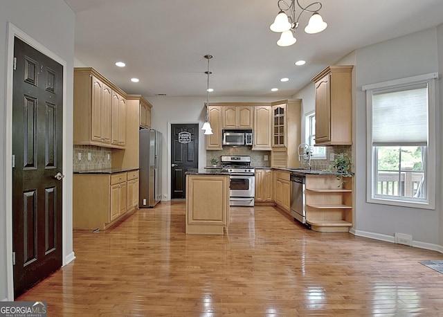 65 Tapestry Ln, Newnan, GA 30265 - kitchen with stainless steel appliances, light brown cabinetry, a center island, light wood finished floors, and decorative backsplash