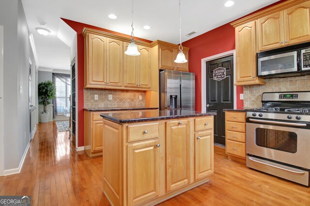 kitchen with stainless steel appliances, a kitchen island, light wood-type flooring, decorative backsplash, and baseboards