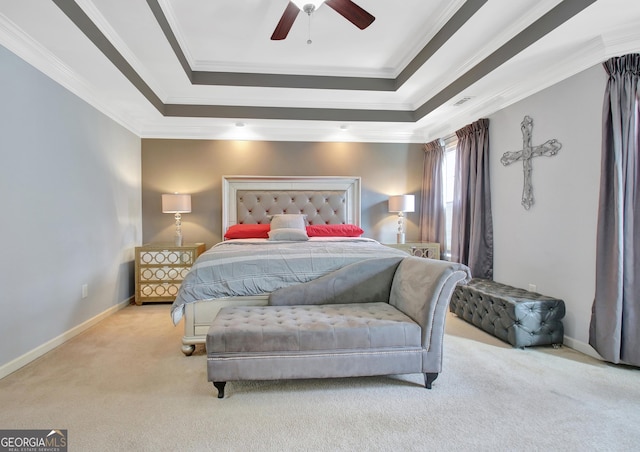 carpeted bedroom featuring a raised ceiling, ornamental molding, baseboards, and a ceiling fan