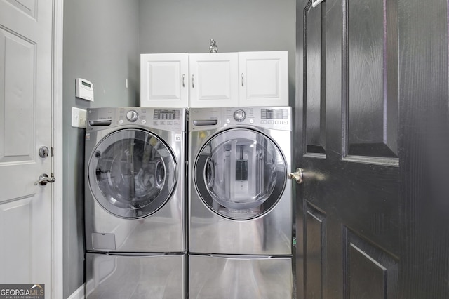 clothes washing area featuring independent washer and dryer and cabinet space