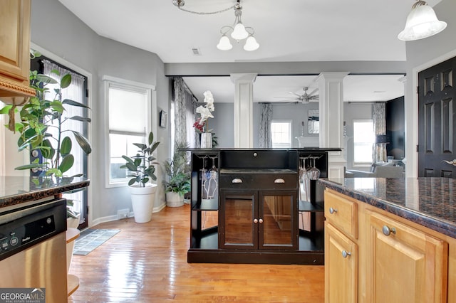 kitchen with stainless steel dishwasher, light wood-style floors, ornate columns, and a ceiling fan