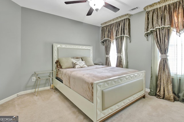 bedroom with light colored carpet, baseboards, and ceiling fan