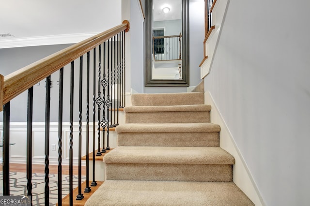 stairs featuring visible vents, wood finished floors, and crown molding