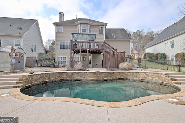 rear view of property with a wooden deck, stairway, a fenced backyard, and a chimney