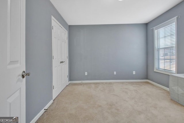 unfurnished bedroom featuring carpet flooring, baseboards, and a closet