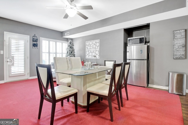 dining space featuring ceiling fan and baseboards