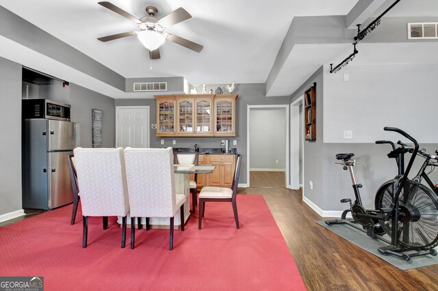 65 Tapestry Ln, Newnan, GA 30265 - dining room with dark wood-type flooring, bar with sink, baseboards, and ceiling fan