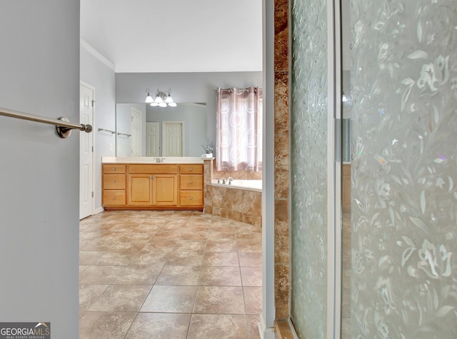 full bath with tile patterned flooring, a chandelier, a garden tub, ornamental molding, and vanity