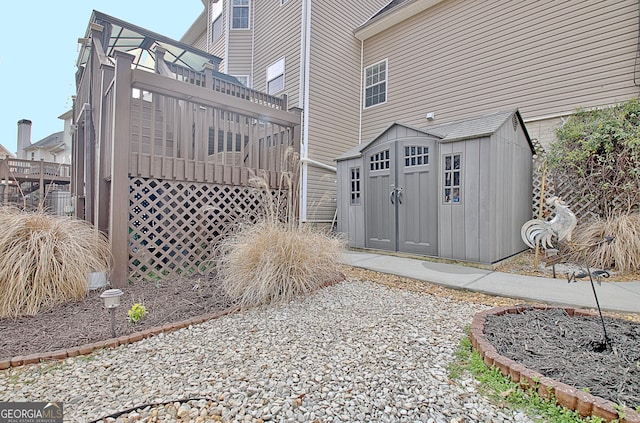 view of side of home with a shed, an outdoor structure, and a wooden deck