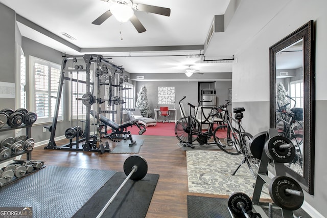 workout area with visible vents, wood finished floors, baseboards, and ceiling fan