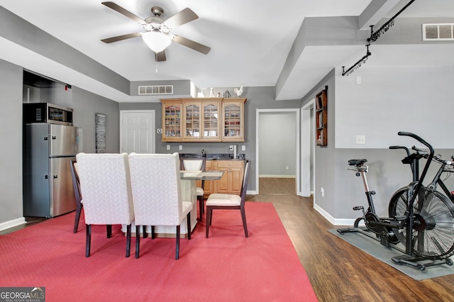 dining area with ceiling fan, visible vents, dark wood-style floors, and indoor wet bar