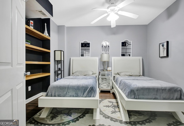 bedroom featuring visible vents, baseboards, wood finished floors, and a ceiling fan