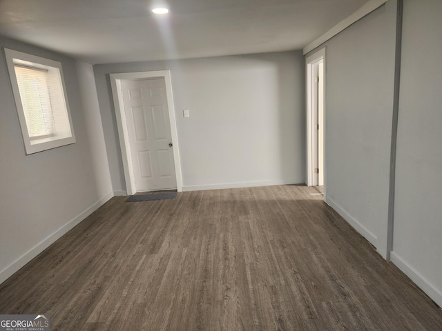 empty room featuring baseboards and dark wood-style flooring