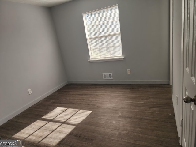 spare room with visible vents, baseboards, and wood finished floors