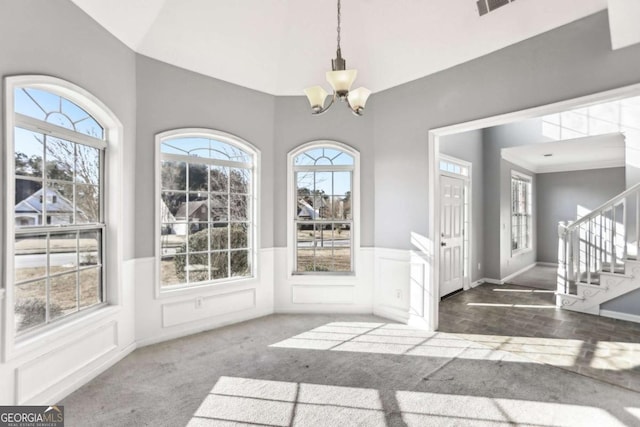 interior space featuring stairs, a wealth of natural light, and a chandelier