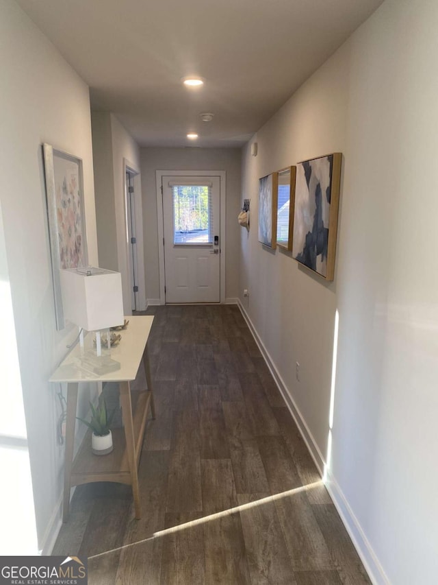 hall featuring wood finished floors and baseboards