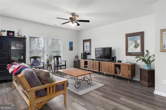 living room with baseboards, ceiling fan, and dark wood-style flooring