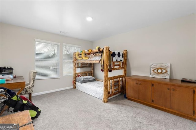 bedroom featuring visible vents, baseboards, and light carpet