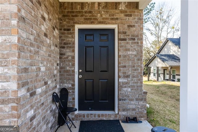 view of exterior entry with brick siding