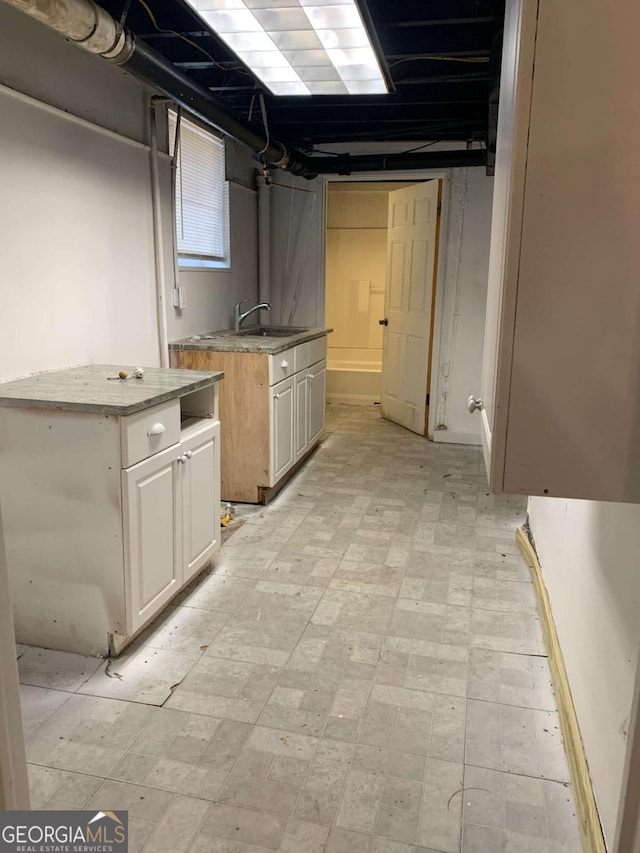 1649 NW Ezra Church Dr NW, Atlanta, GA 30314 - kitchen with light floors, white cabinets, and a sink
