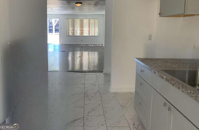 kitchen featuring baseboards and marble finish floor