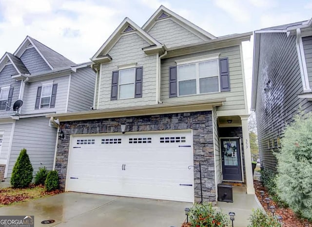 view of front of home featuring stone siding, concrete driveway, and an attached garage