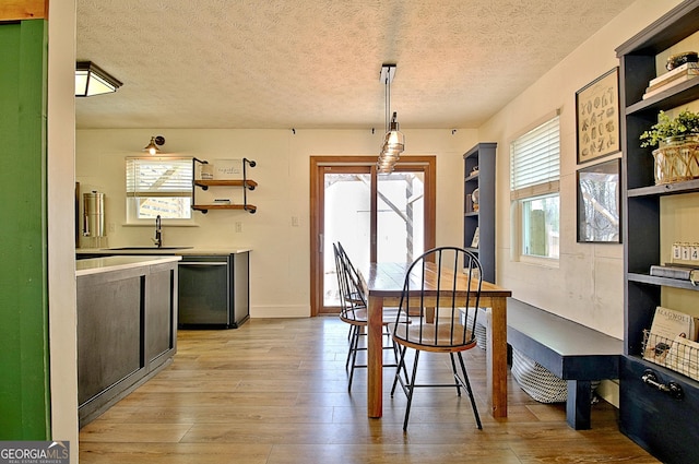 dining area featuring a textured ceiling and light wood finished floors