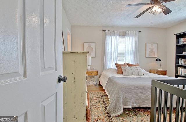 bedroom featuring a textured ceiling, ceiling fan, and wood finished floors