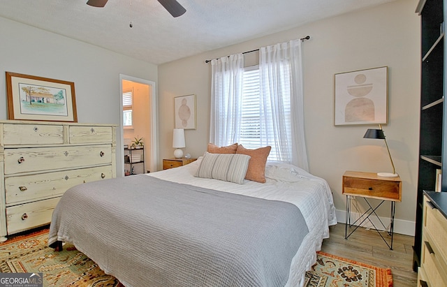 bedroom featuring a ceiling fan, wood finished floors, and baseboards