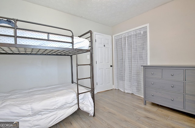 unfurnished bedroom with light wood finished floors and a textured ceiling