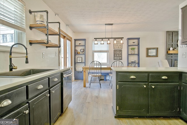 kitchen featuring open shelves, a sink, light countertops, green cabinetry, and dishwasher