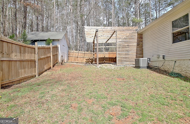 view of yard featuring a fenced backyard and central AC