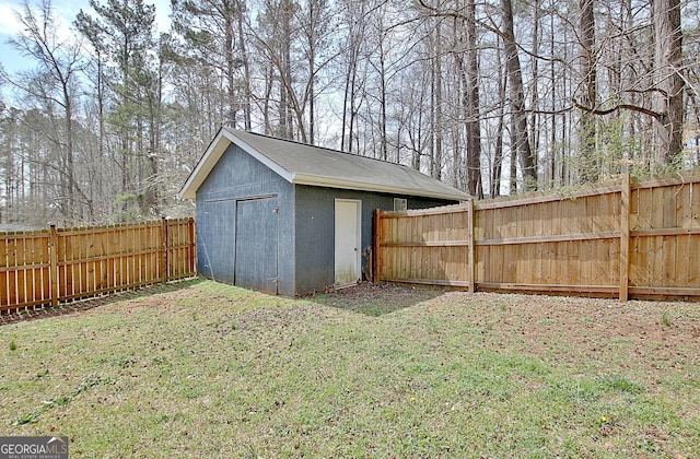 view of yard with an outbuilding, a fenced backyard, and a shed