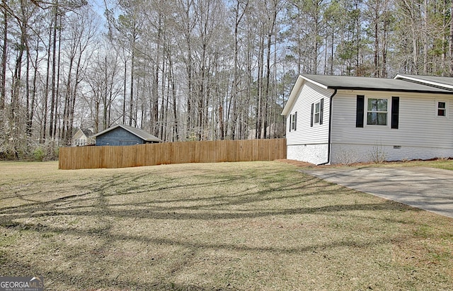 view of side of property featuring a yard, fence, and crawl space